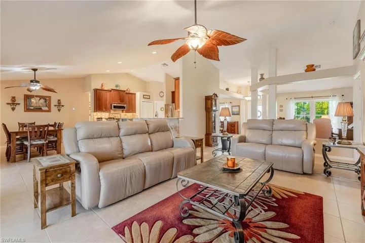 Tiled living room with high vaulted ceiling and ceiling fan