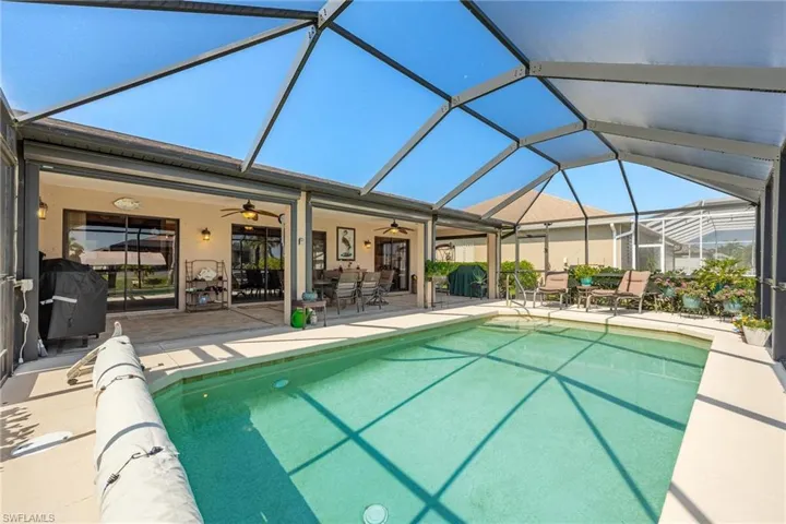 View of swimming pool featuring a patio, a lanai, ceiling fan, and grilling area