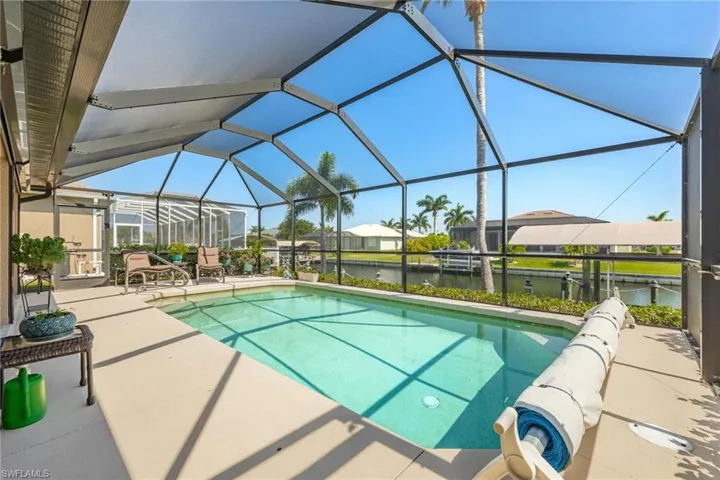 View of swimming pool featuring a lanai, a water view, and a patio