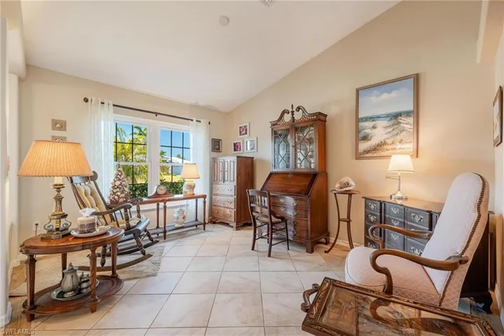 Sitting room with light tile flooring and lofted ceiling