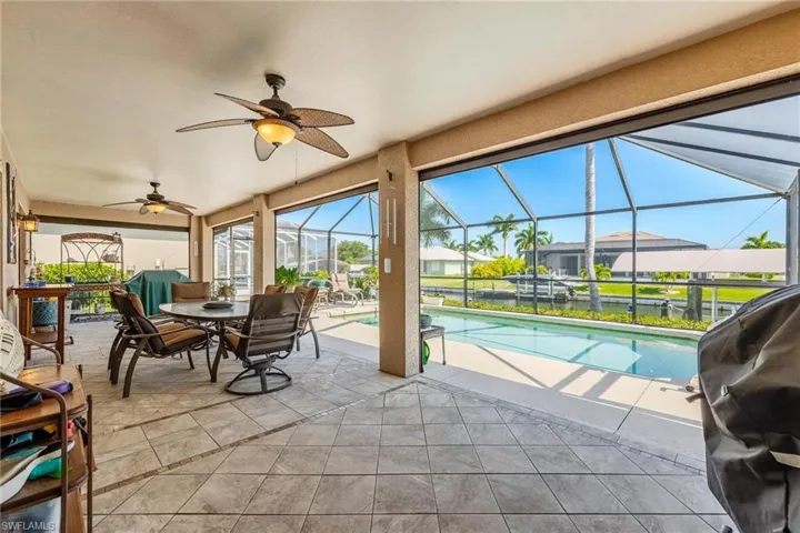 View of swimming pool featuring a patio, a lanai, grilling area, and ceiling fan