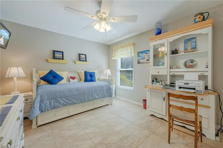 Tiled bedroom featuring ceiling fan