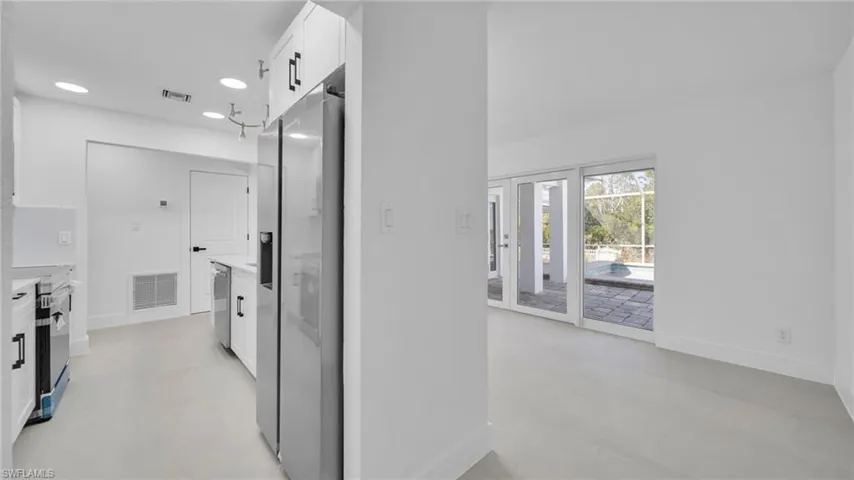 Hall featuring baseboards and concrete floors