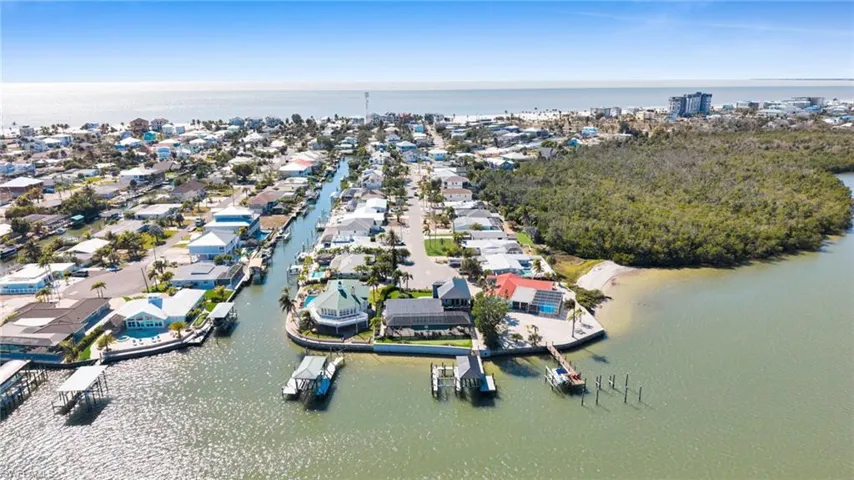 Aerial view of property and surrounding area with a large body of water and nearby suburban area