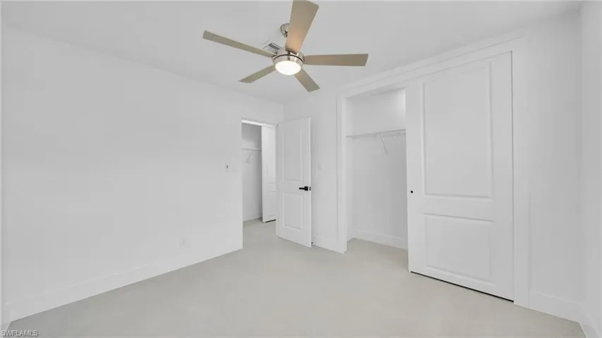 Unfurnished bedroom with a ceiling fan and a closet