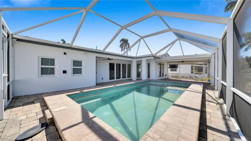 Swimming pool with a sunroom, a lanai, and a patio