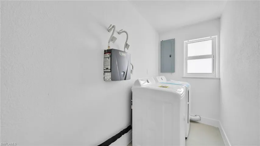 Laundry area featuring independent washer and dryer and electric panel