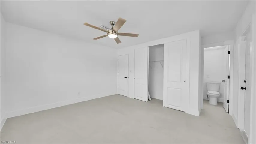 Unfurnished bedroom with concrete floors, a closet, and a ceiling fan