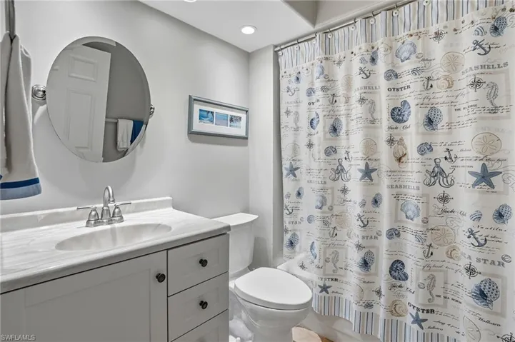 Full bath with vanity, shower / bath combo with shower curtain, and recessed lighting