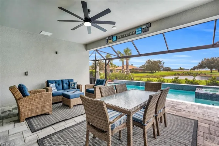 View of patio with a pool with hot tub, ceiling fan, panoramic screen with bautiful waterfront, pool water feature, and outdoor lounge area
