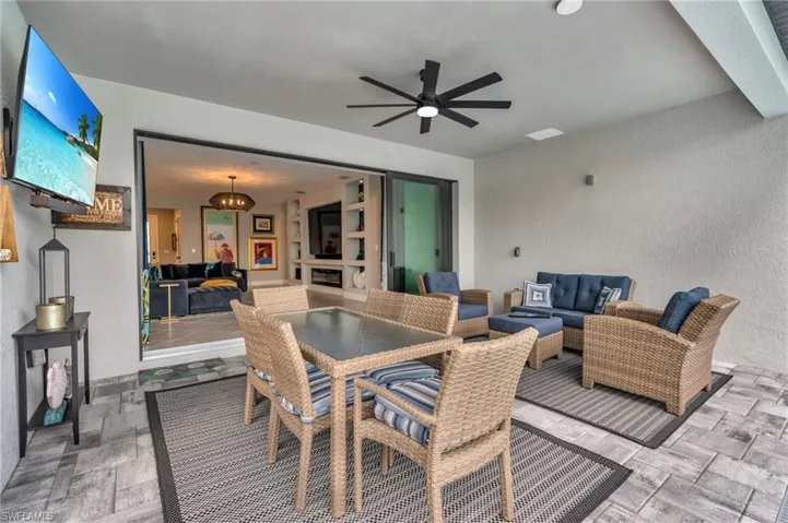 View of patio with outdoor lounge area and ceiling fan and TV