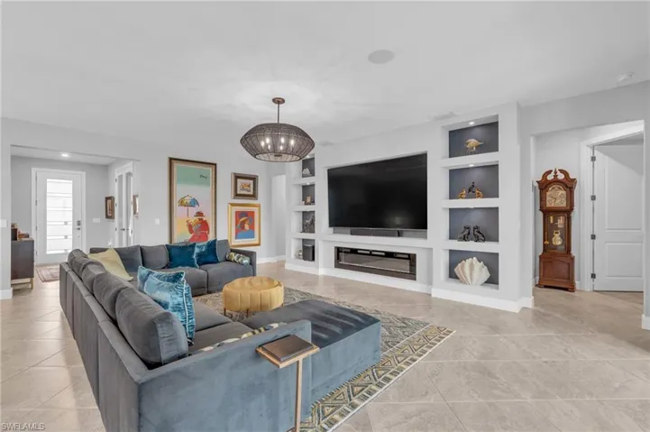 Living room featuring a chandelier, fireplace and custom built in