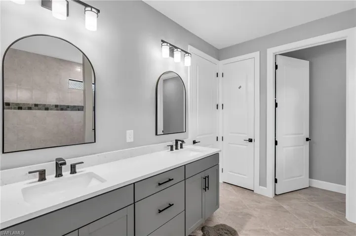Primary Bathroom featuring double vanity, an extra large tile shower with rainfall shower head