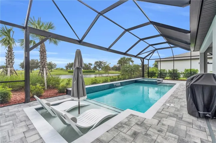 View of pool featuring a patio area, panoramic screen enclosure, grilling area, pool water feature, and a water view