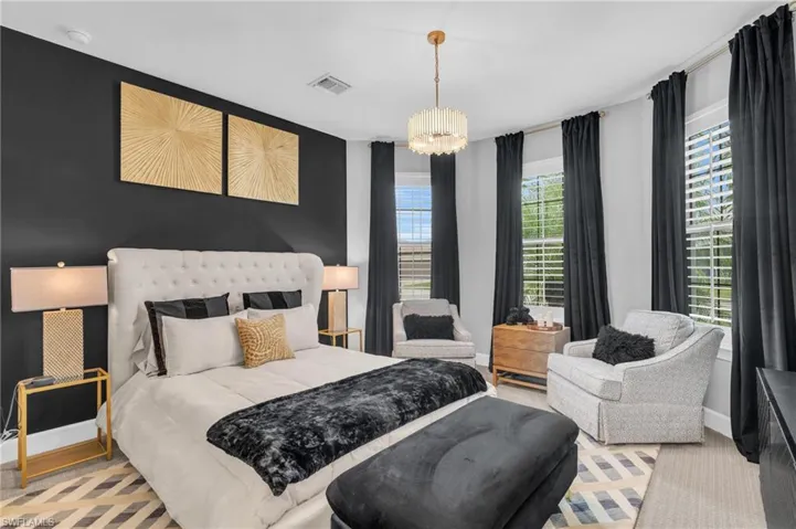 Bedroom ensuite featuring a notable chandelier, bay windows for ample lighting