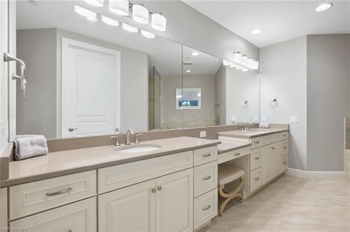 Primary Bath with custom cabinetry, featuring built in dressing vanity and decorative lights.
