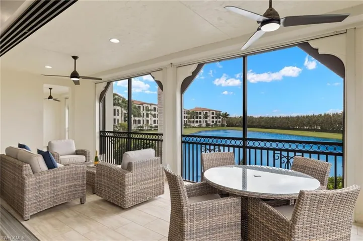Lanai featuring a water view, outdoor dining space, ceiling fans, and motorized hurricane/privacy screens on all screened areas