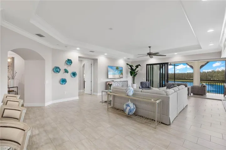 Great Room with a ceiling fan, crown molding, and a tray ceiling.