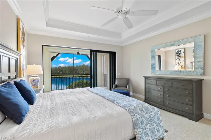 Primary bedroom with a tray ceiling, access to lanai.