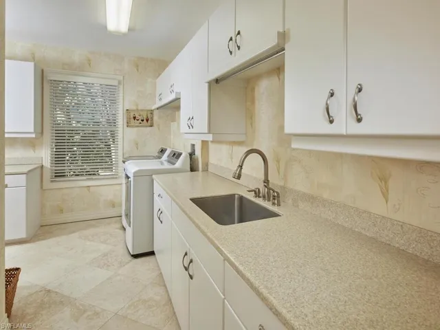 Large laundry room with sink and extra cabinetry.