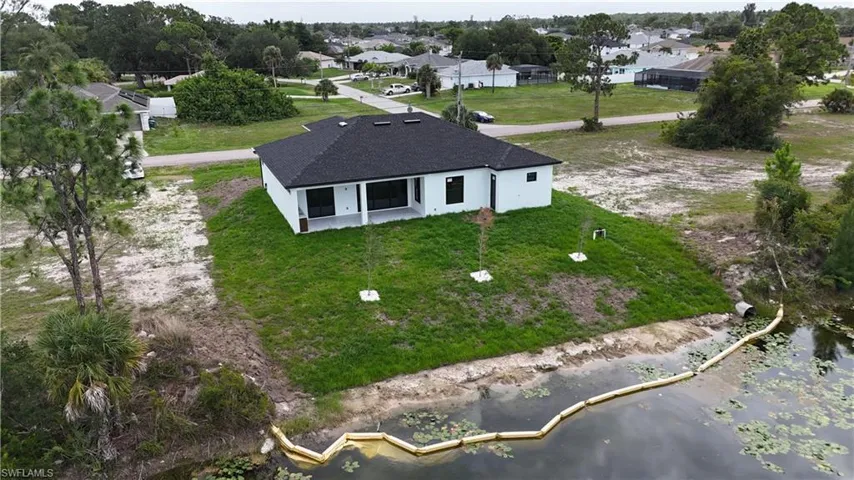 Contemporary single-story residence featuring a white exterior and a black shingle roof