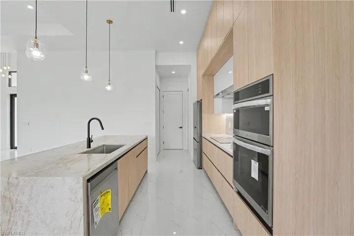 Modern kitchen with a substantial island featuring a built-in sink and a matte black faucet