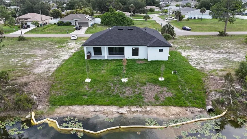Contemporary single-story residence with a dark shingle roof and a light-colored exterior