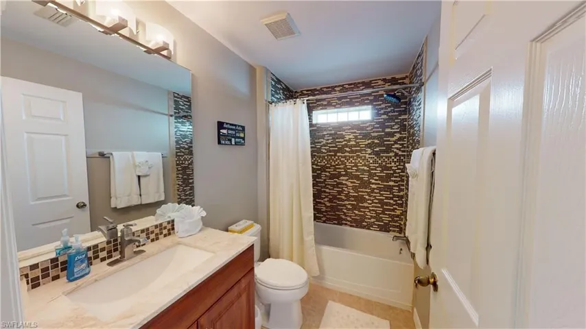 Full bathroom with vanity, tile patterned flooring, toilet, and shower / tub combo with curtain