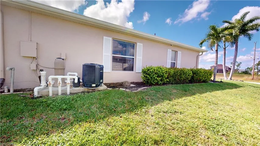 side of home showing pool pumps and heater