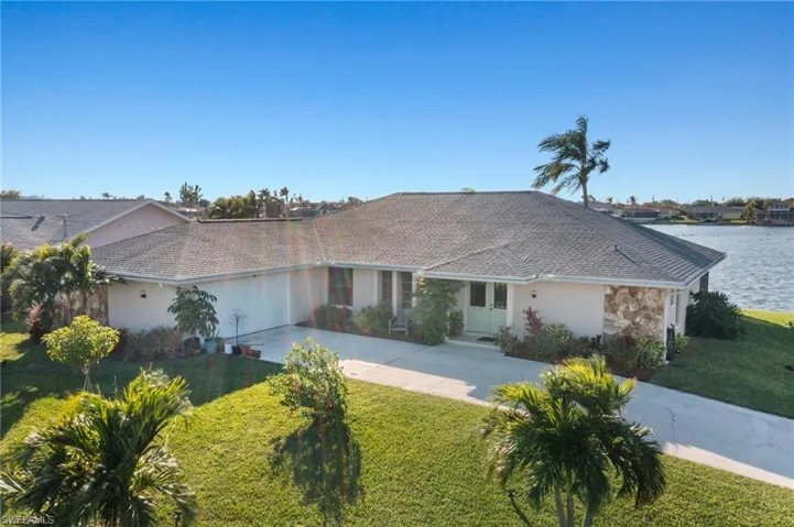Ranch-style home featuring a front lawn and a water view