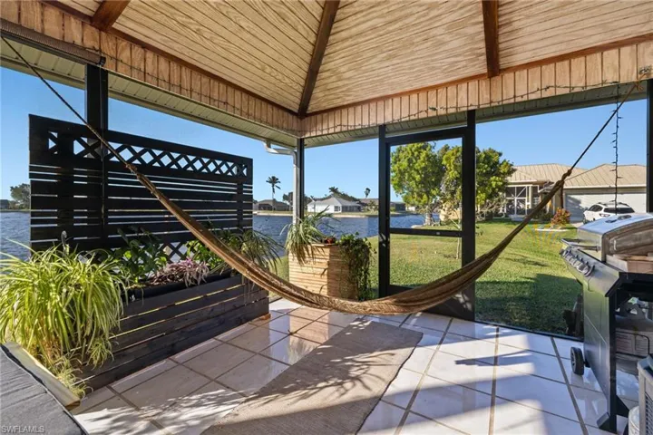 Sunroom with a water view and lofted ceiling