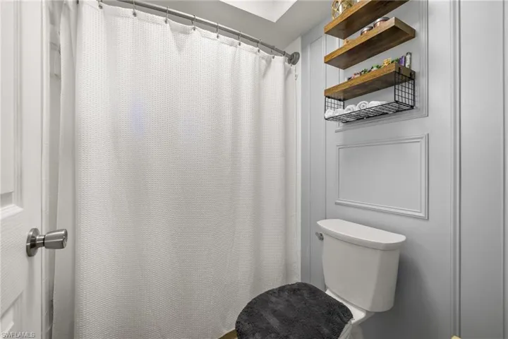 Bathroom with curtained shower and toilet