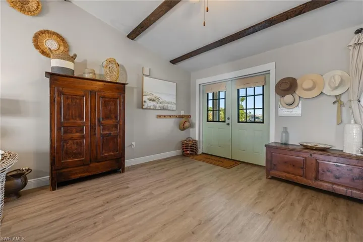 Foyer featuring french doors, lofted ceiling with beams, and light hardwood / wood-style floors