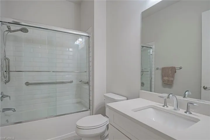 Guest Bathroom featuring vanity and enclosed tub / shower combo