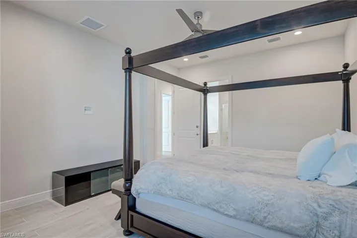 Bedroom with light wood-type flooring, ceiling fan, and recessed lighting