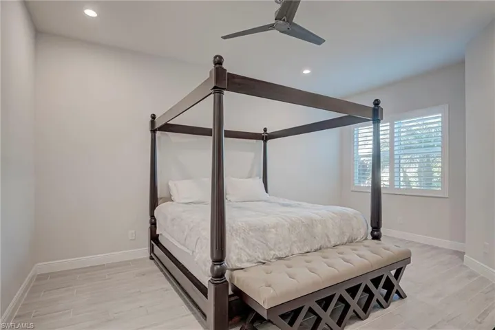 Bedroom with light wood finished floors, a ceiling fan, and recessed lighting