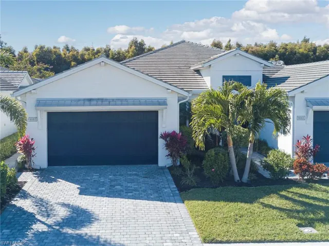 View of front of home with a garage, decorative driveway, a front lawn, stucco siding, and a tile roof