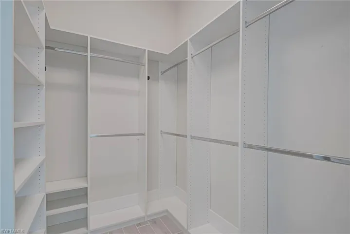 2nd bedroom walk in closet with light wood finished floors