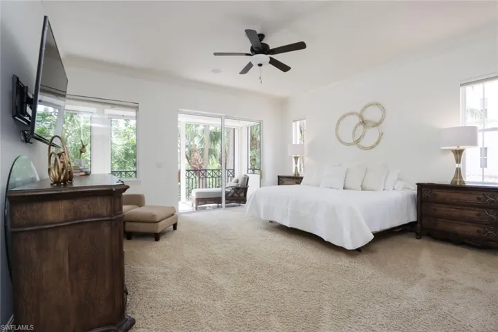 Carpeted bedroom with access to exterior, ornamental molding, multiple windows, and a ceiling fan