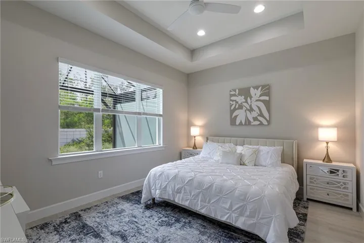 Bedroom featuring a raised ceiling, a ceiling fan, and recessed lighting