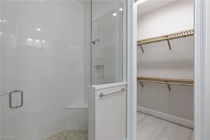 Full bath with a spacious closet and a walk in shower