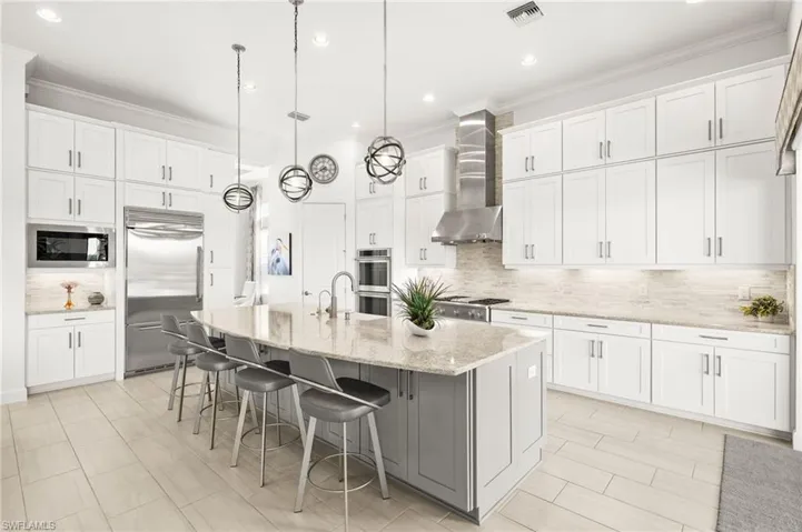 Upgraded kitchen with monogram appliances, built-in refrigerator, R/O system, extra cabinets below island & third row of cabinets.