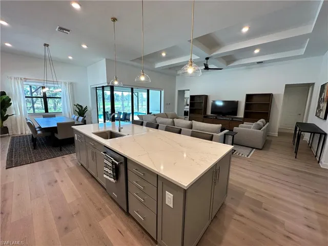 Kitchen with gray cabinetry, pendant lighting, light wood finished floors, coffered ceiling, and beamed ceiling