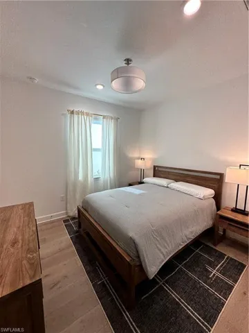 Bedroom featuring wood finished floors, a textured ceiling, and recessed lighting