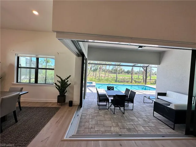 Dining area with light wood-style floors, a sunroom, and recessed lighting