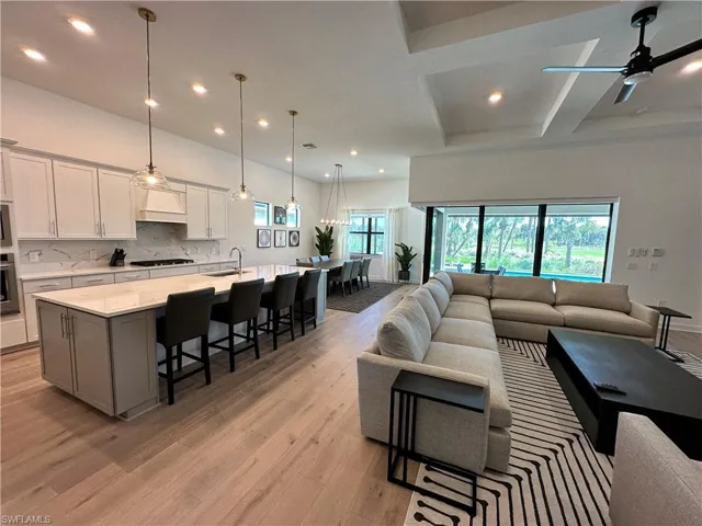 Living area with a ceiling fan, recessed lighting, and light wood-type flooring