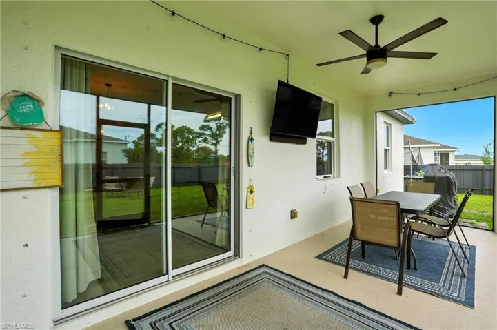 Sunroom featuring outdoor dining area, ceiling fan, and a patio