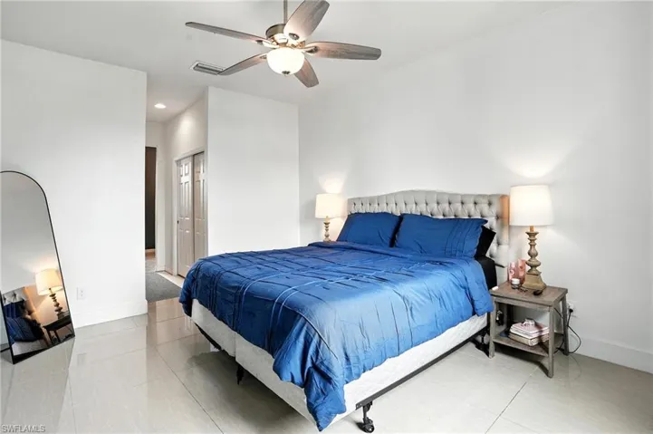 Bedroom with recessed lighting, ceiling fan, a closet, and light tile patterned floors