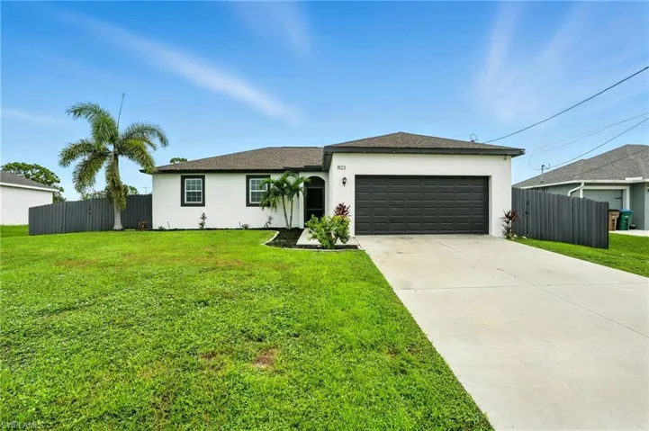 Single story home featuring stucco siding, an attached garage, driveway, and roof with shingles