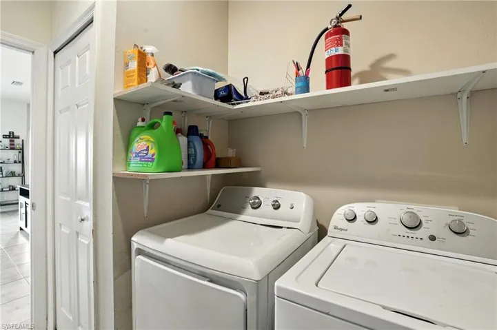 Laundry room with washer and dryer and tile patterned flooring